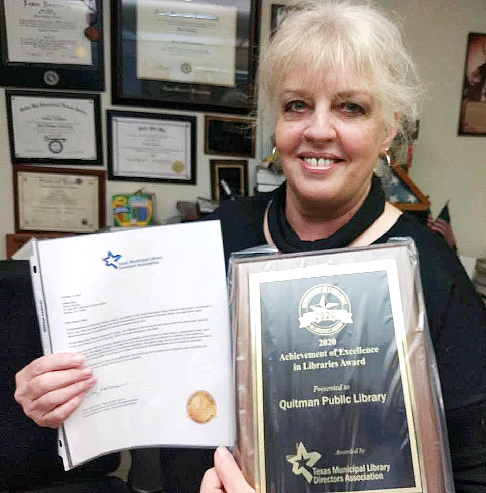 Quitman Librarian Delene Allen shows off the excellence award recently received by the library.